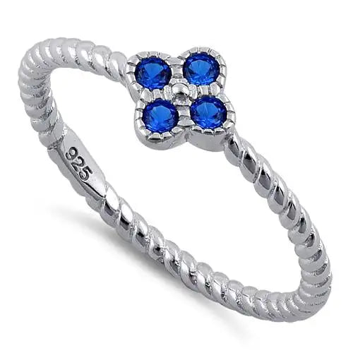 Anillo con circonita cúbica de espinela azul y flor de cuerda