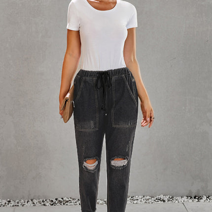 Jogger de mezclilla con bolsillos desgastados y cordón ajustable desgastado 